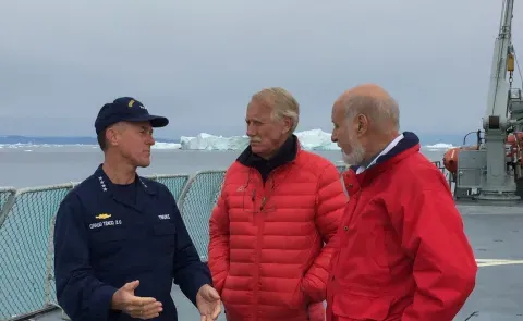 Sen. Angus King of Maine stands with a member of the U.S. Coast Guard on a Coast Guard boat